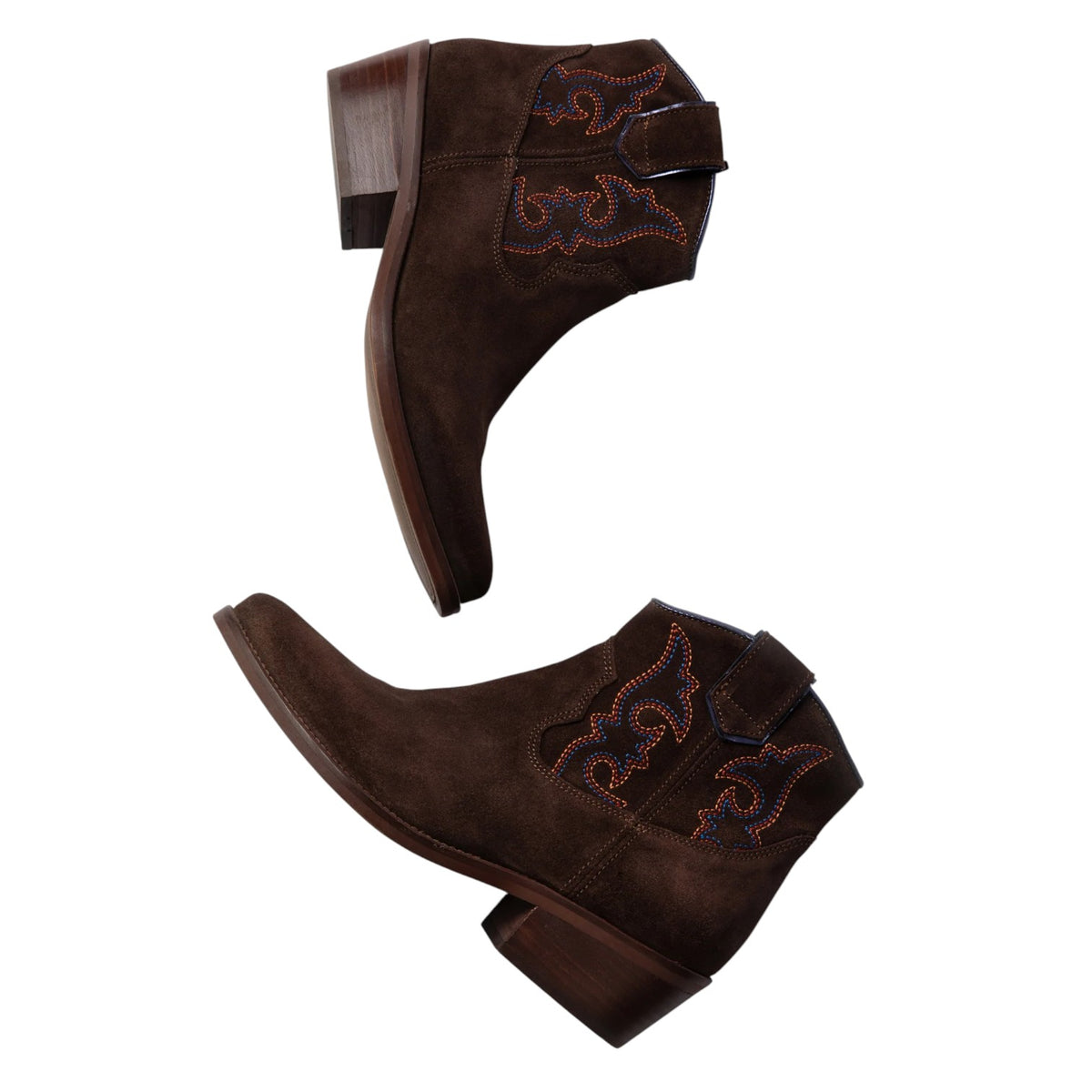 A pair of dark brown suede western ankle boots with decorative embroidered details and a snap strap closure, shown from two angles on a white background.