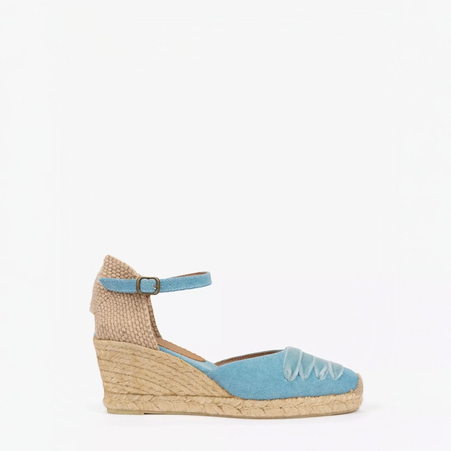 Woven wedge sandal with blue sole and strap on a white background