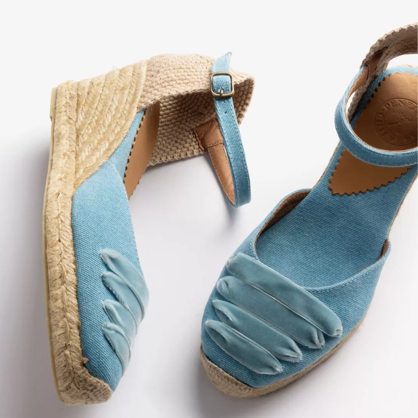 Blue wedge sandals with espadrille sole on a white background