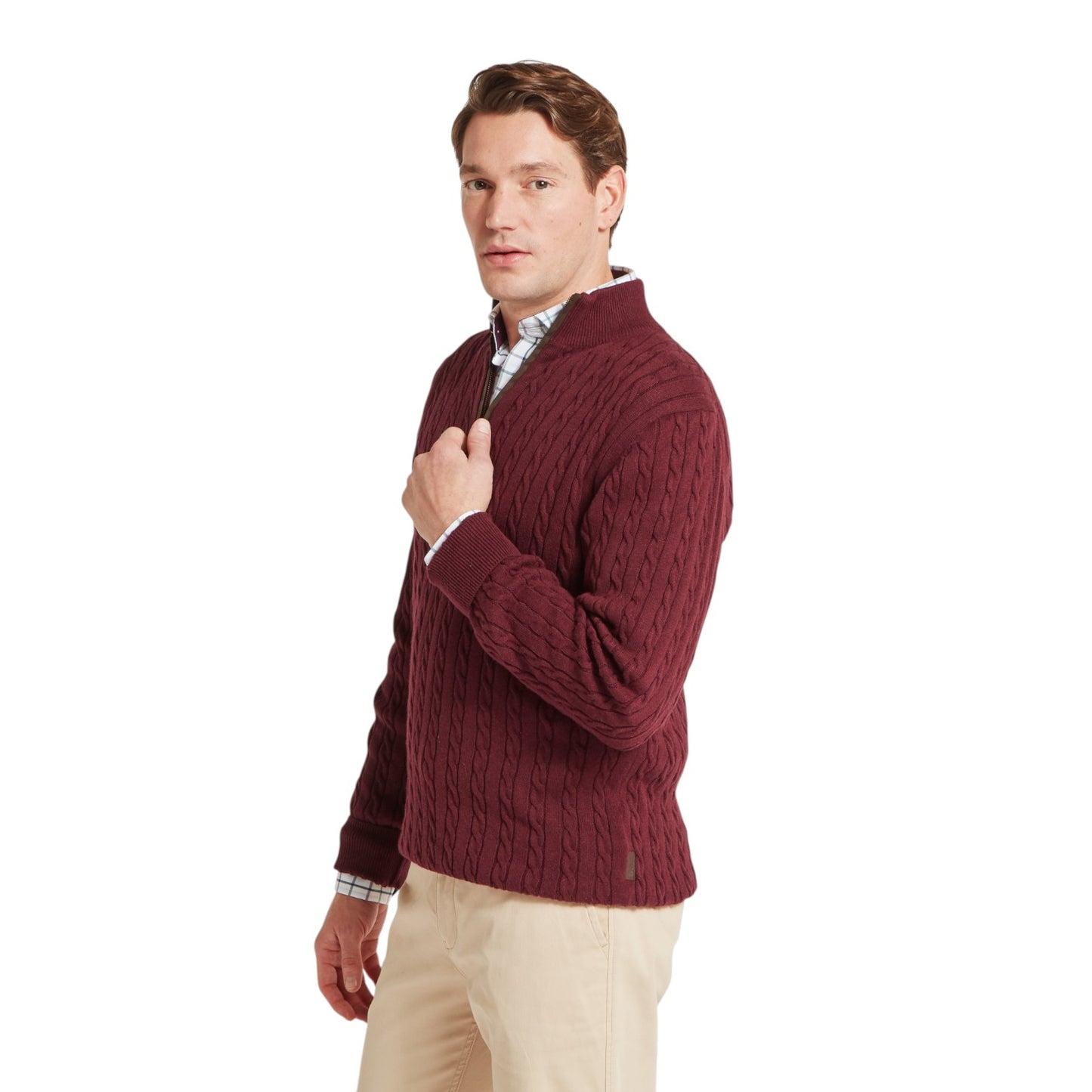 Man wearing a maroon cable knit sweater on a white background
