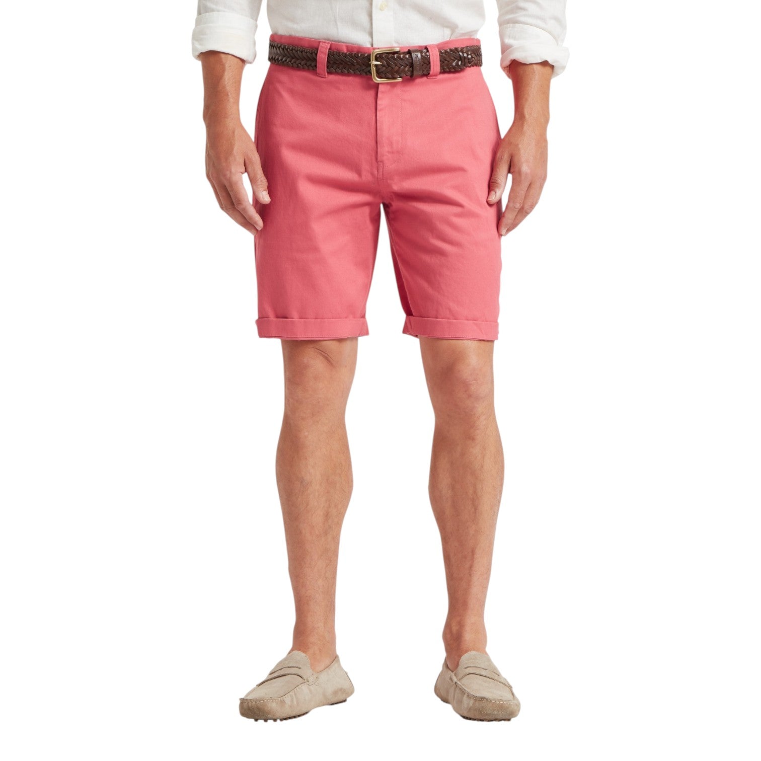 Person wearing pink shorts with a white shirt and beige shoes on a white background
