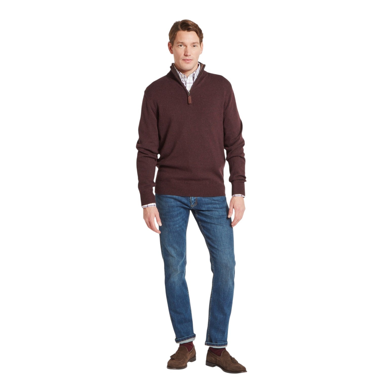 Man wearing a brown sweater and blue jeans on a white background