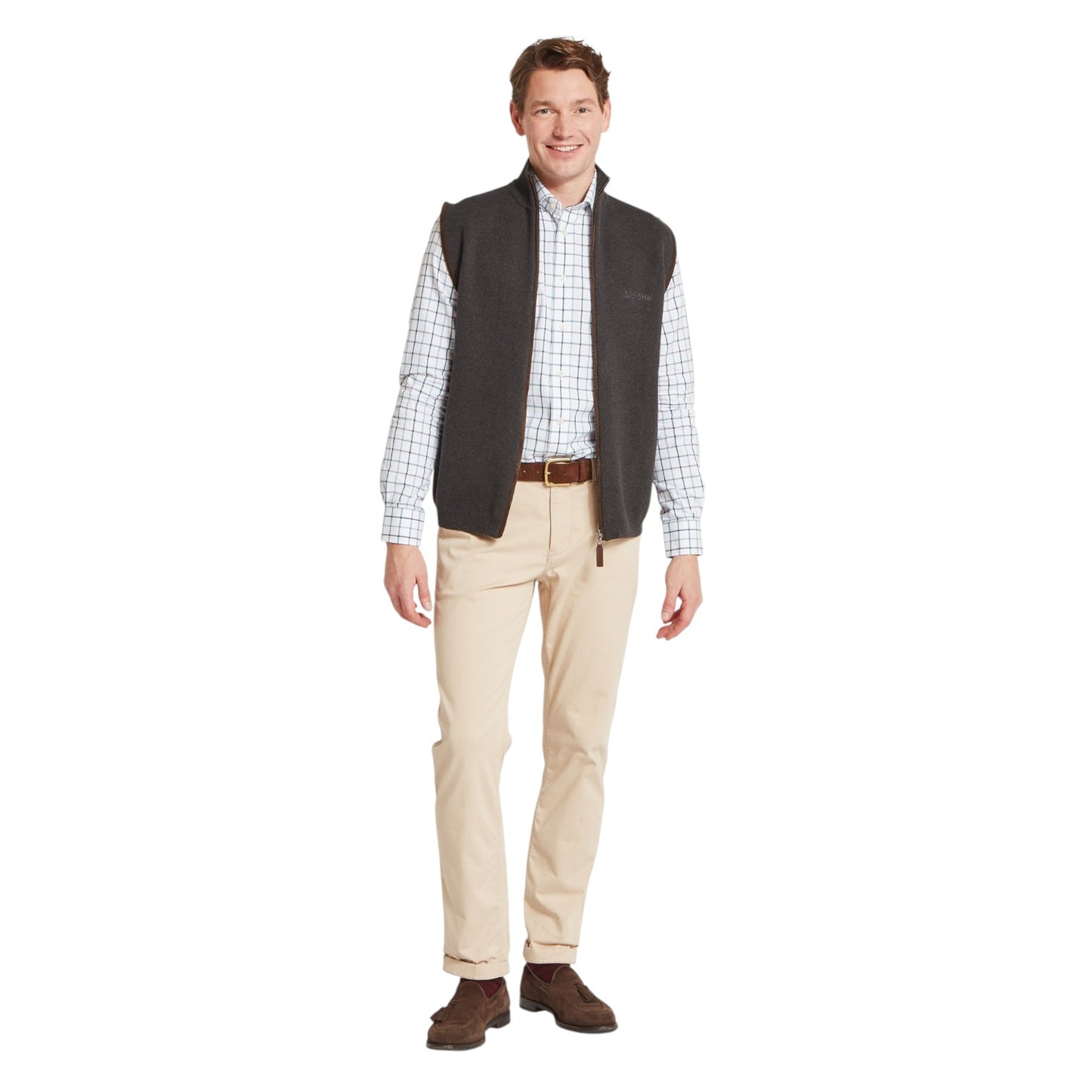 Man wearing a checkered shirt, vest, and beige pants on a white background