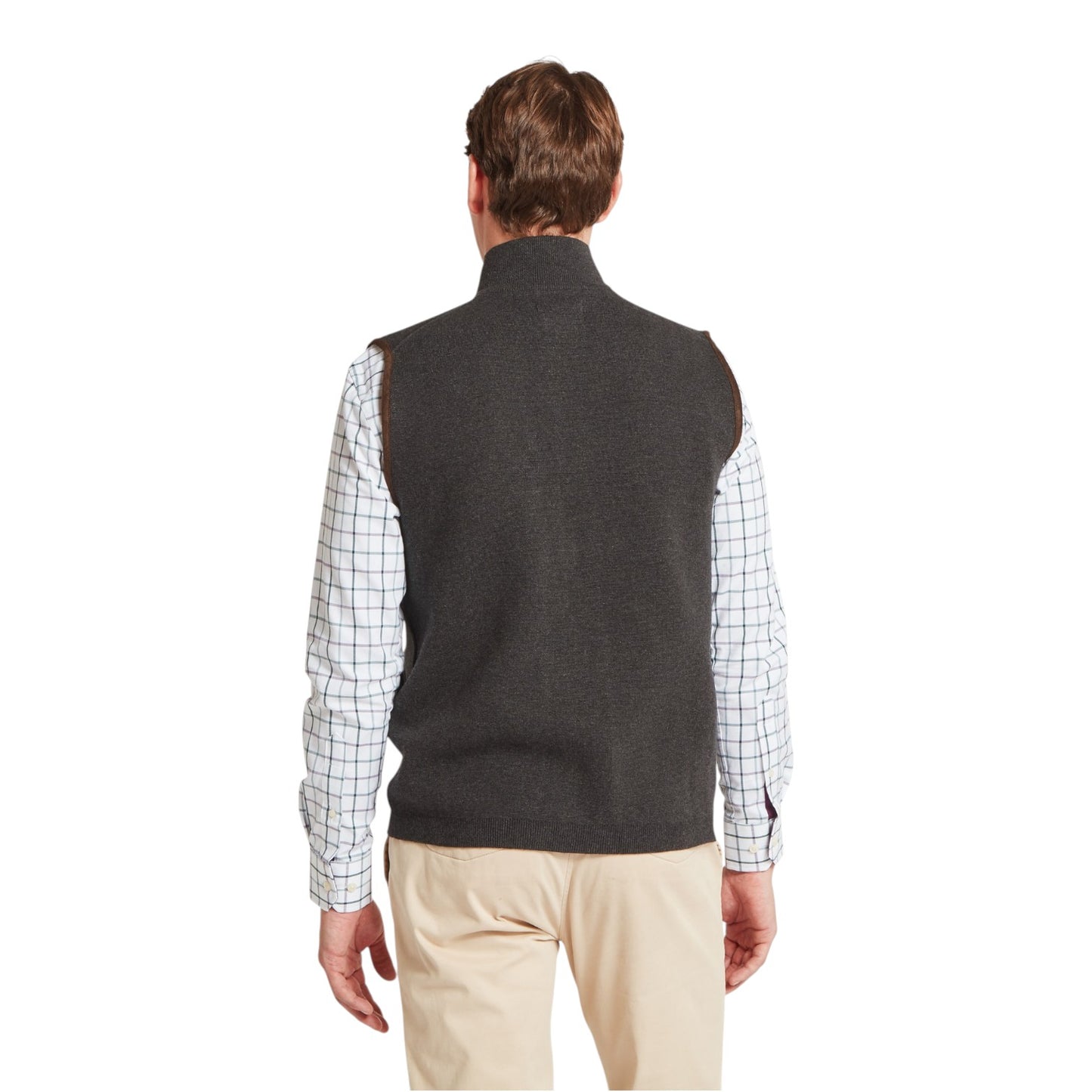 Man wearing a dark gray vest over a plaid shirt on a white background