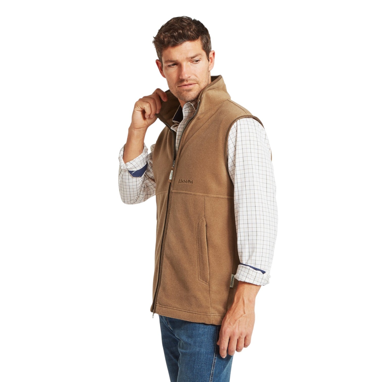 Man wearing a brown vest over a checkered shirt on a white background