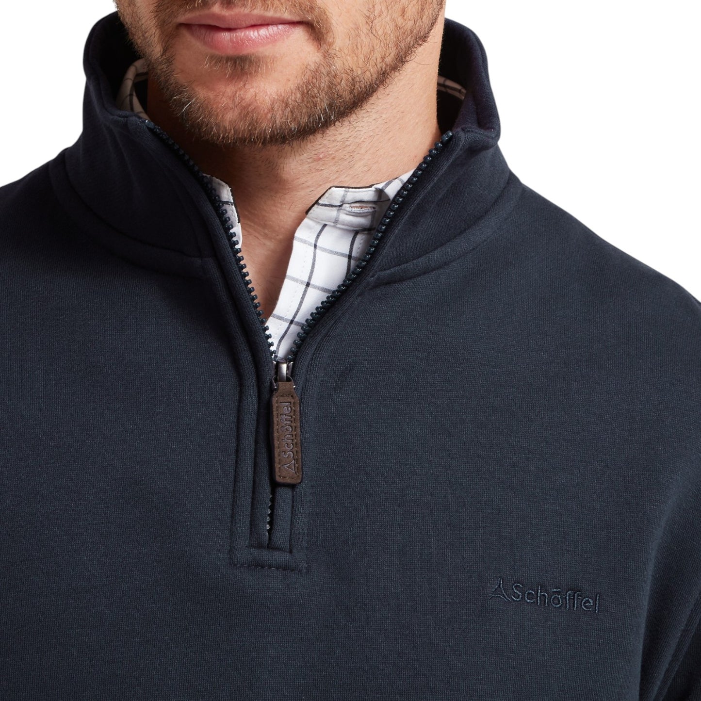 Navy blue pullover with a zipper and plaid shirt underneath on a white background