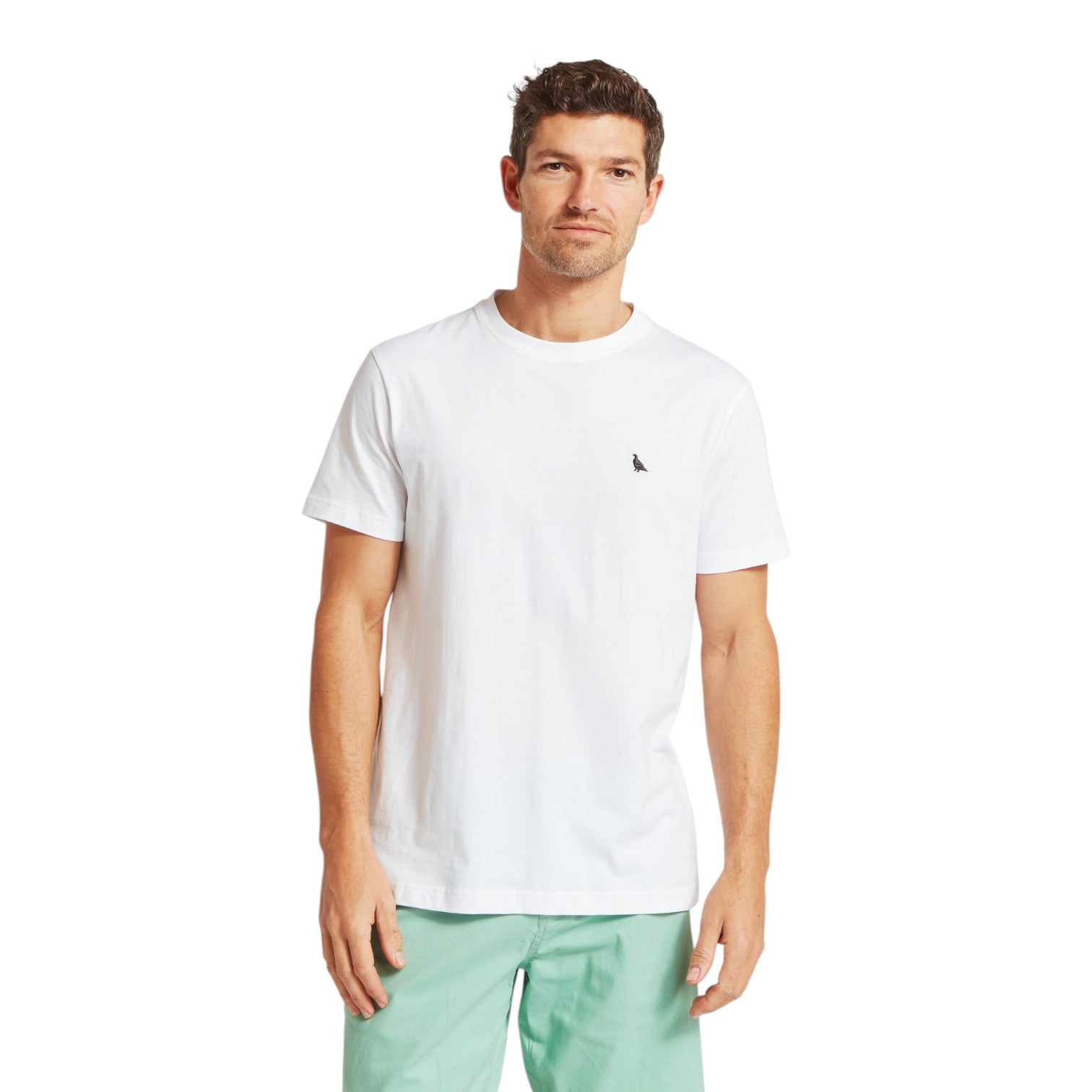 Man wearing a white t-shirt with a small logo on a white background