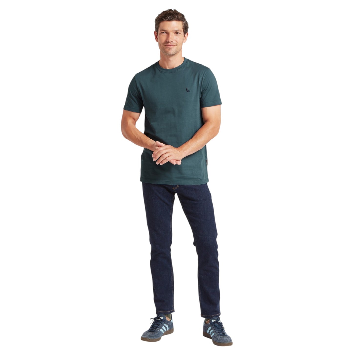 Man wearing a green t-shirt and dark pants on a white background