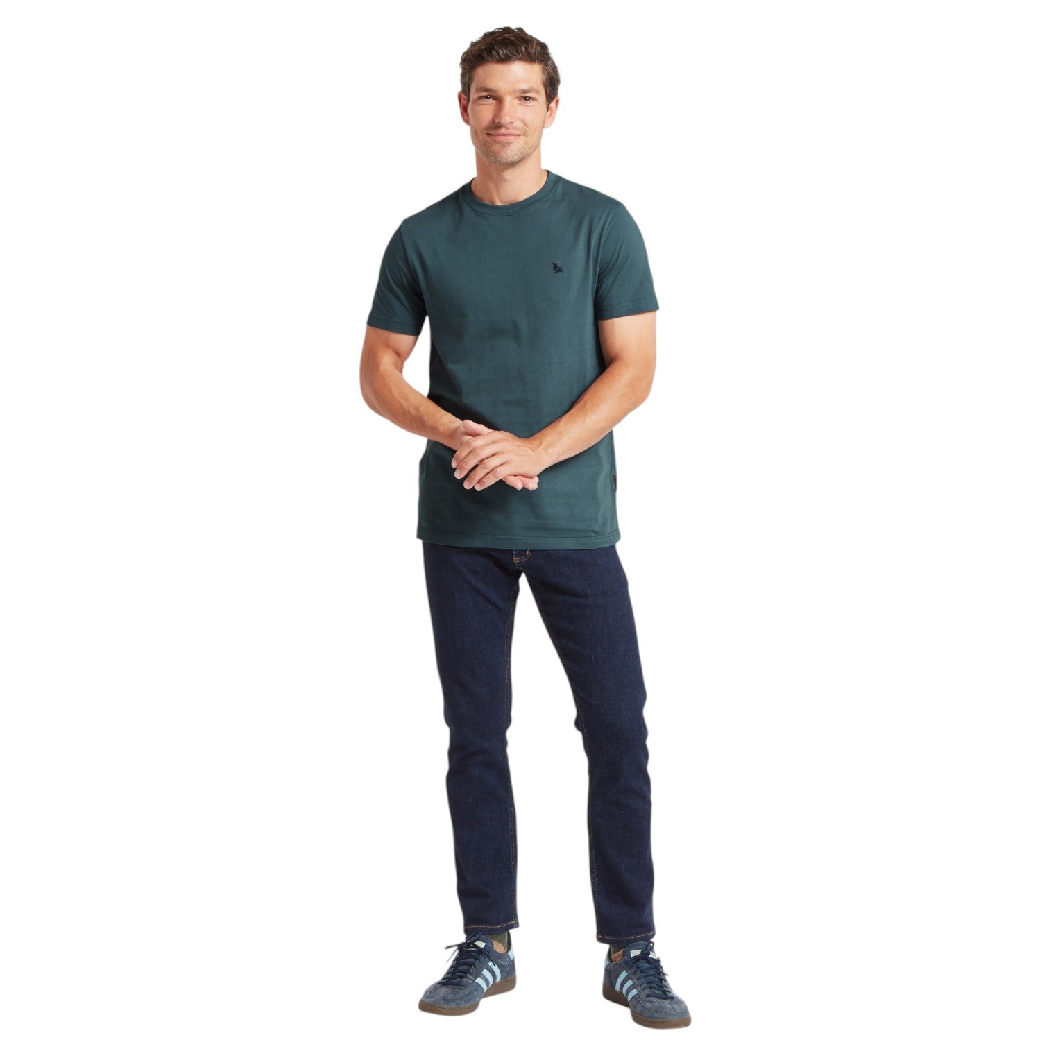 Man wearing a green t-shirt and dark pants on a white background