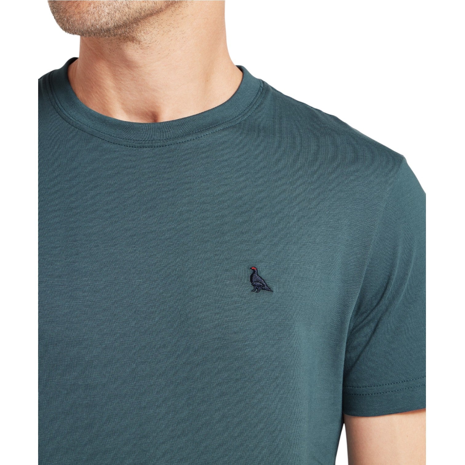 Teal t-shirt with a small logo on a white background