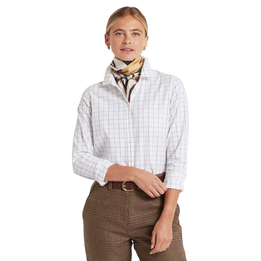 Woman wearing a white checkered shirt and brown plaid pants with a patterned scarf on a white background