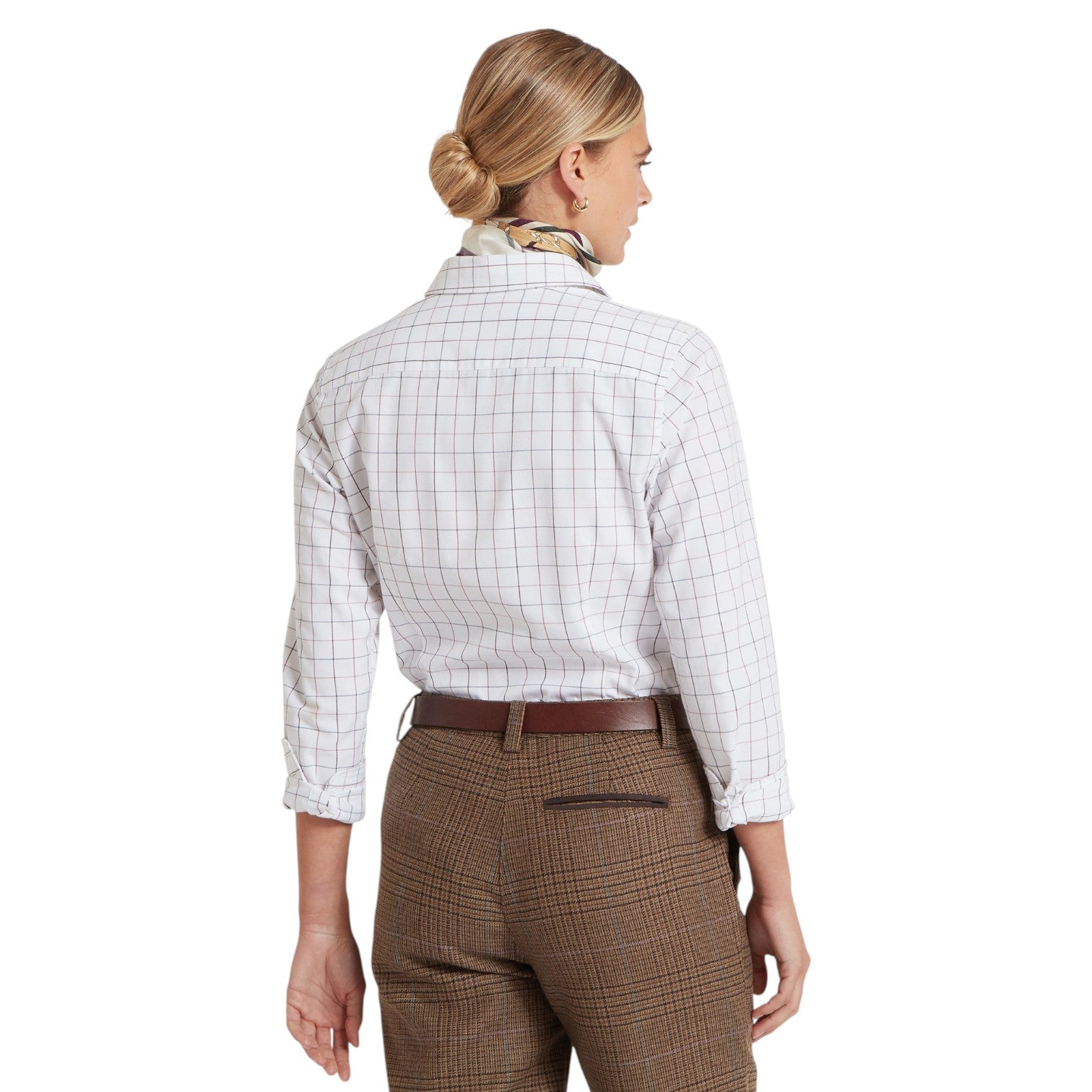 Woman wearing a white checkered shirt and brown plaid pants on a white background