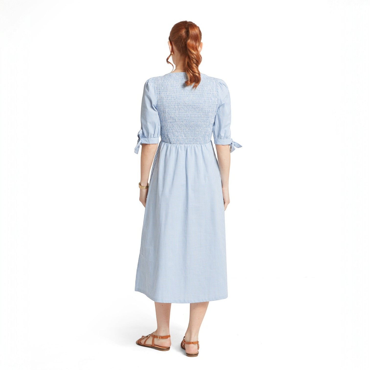 Woman wearing a light blue checkered dress on a white background