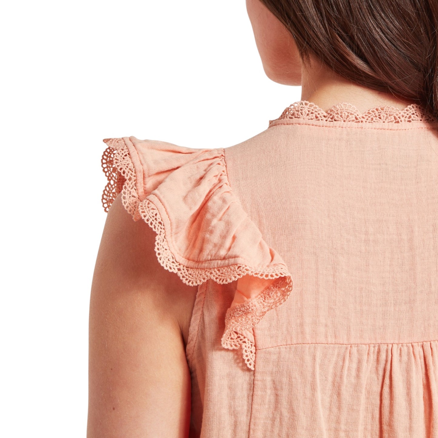 Close-up of a peach-colored dress with lace details on a white background