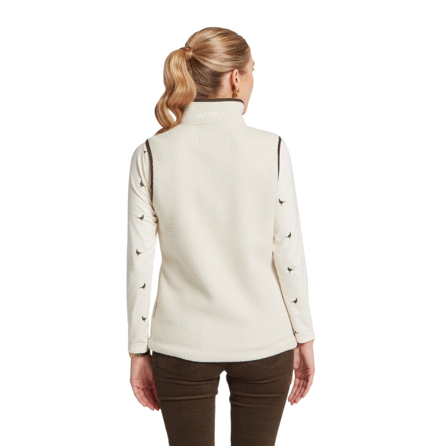 Woman wearing a cream-colored long-sleeve shirt with black accents on a white background