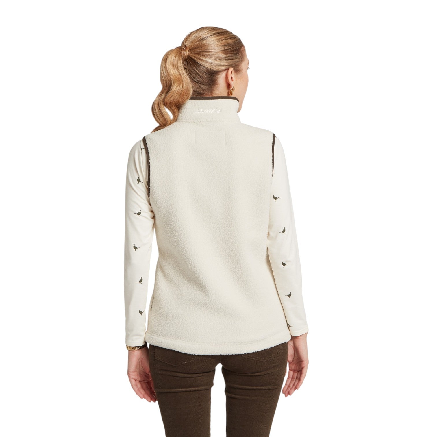 Woman wearing a cream-colored long-sleeve shirt with black accents on a white background