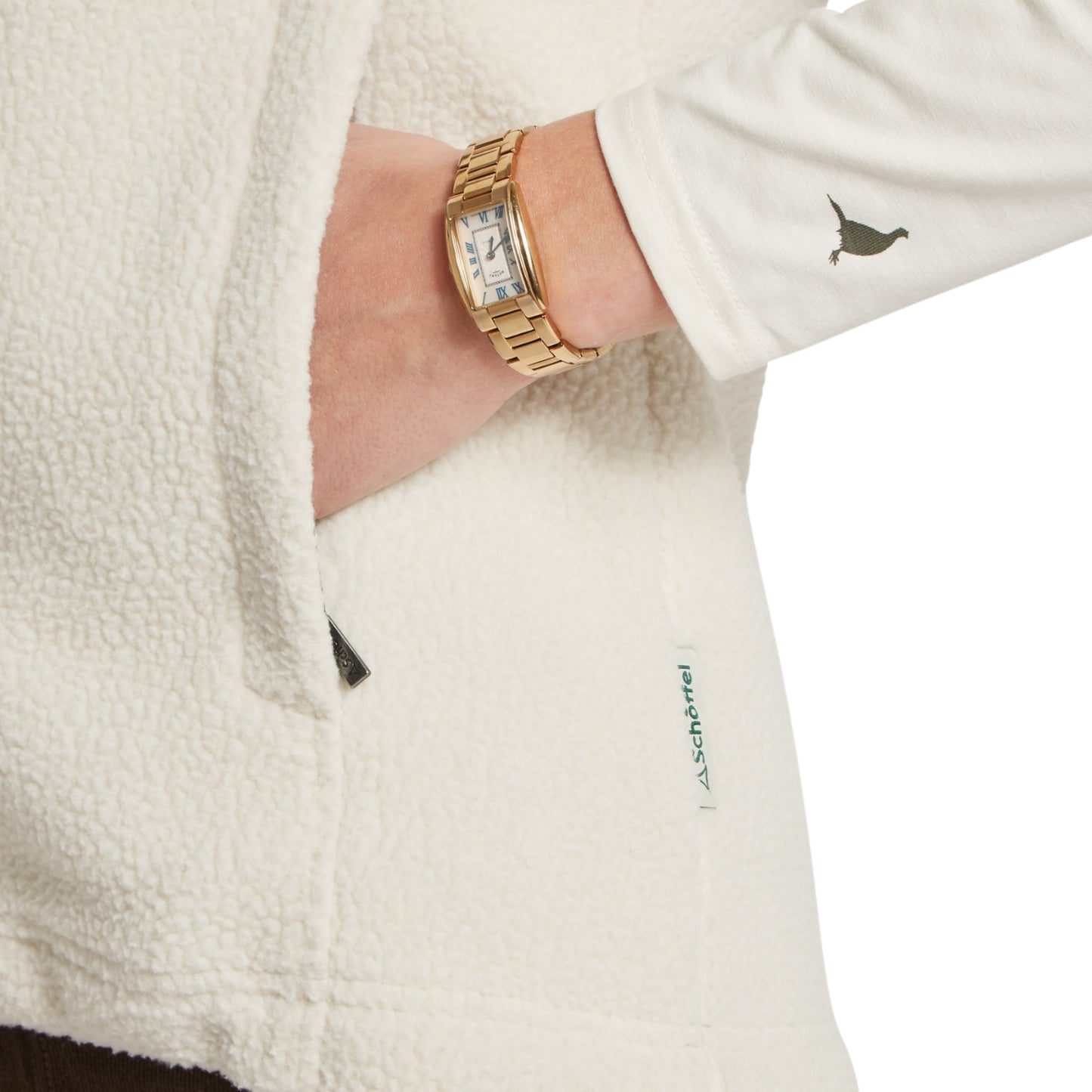Gold watch on a wrist with a white fleece jacket