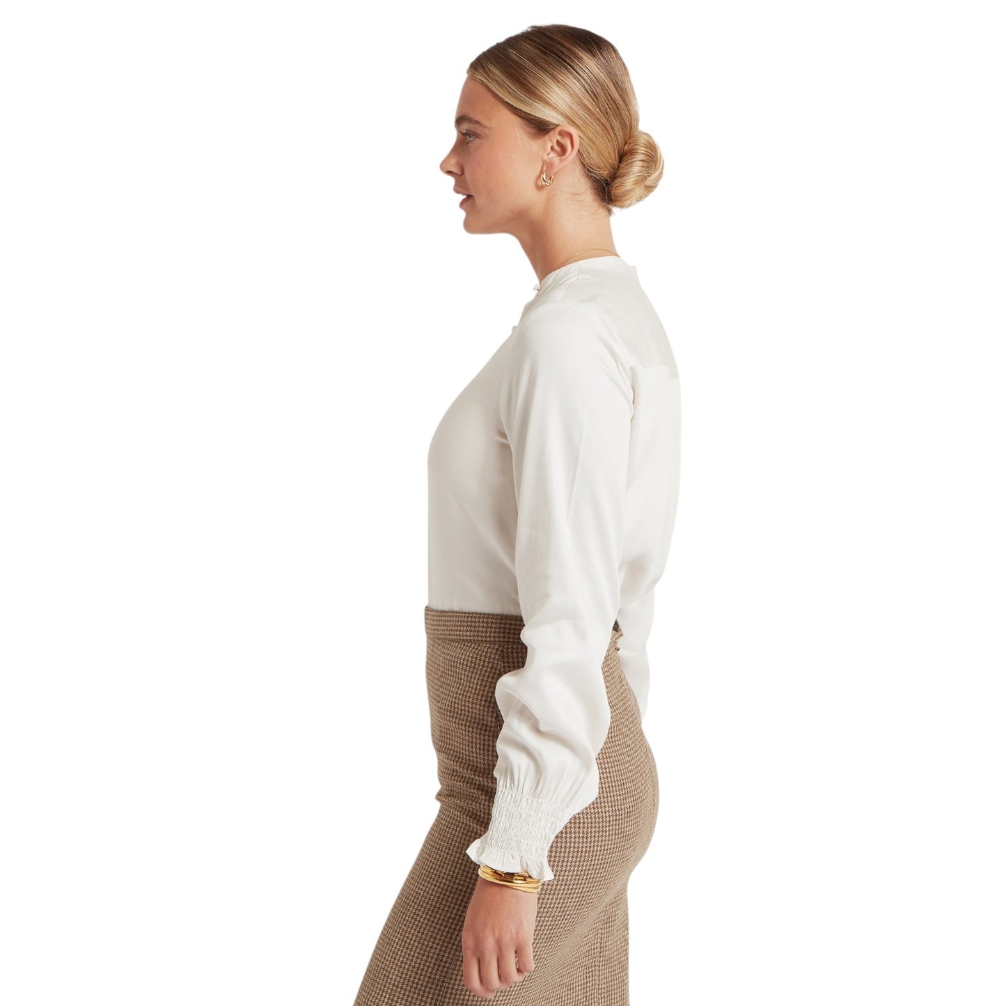 Woman wearing a white blouse and patterned skirt on a white background