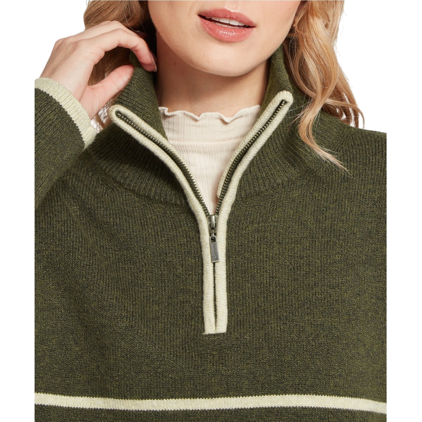Close-up of a person wearing a green sweater with a zipper detail.