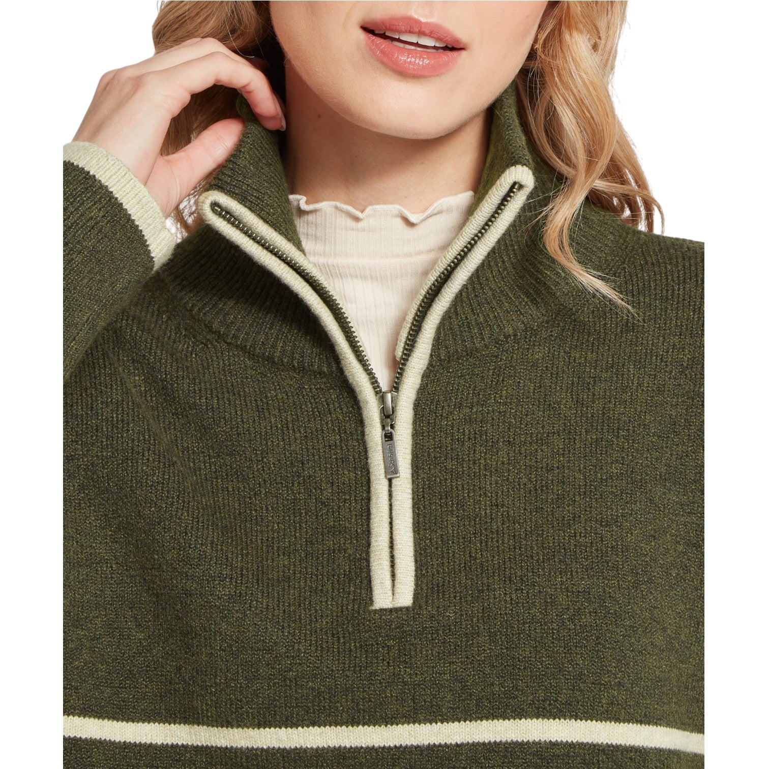 Close-up of a person wearing a green sweater with a zipper detail.