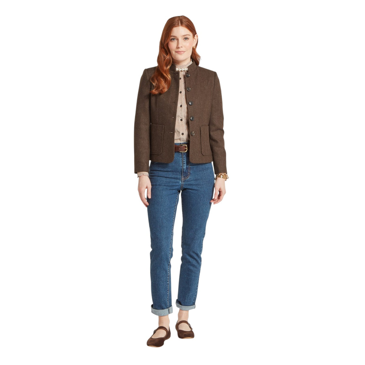 Woman wearing a brown jacket and blue jeans on a white background