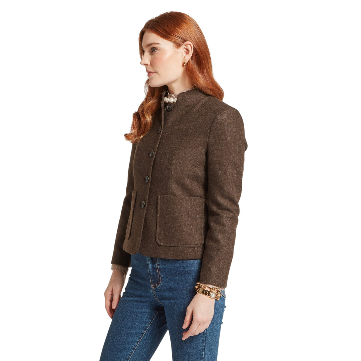 Woman wearing a brown jacket and blue jeans on a white background