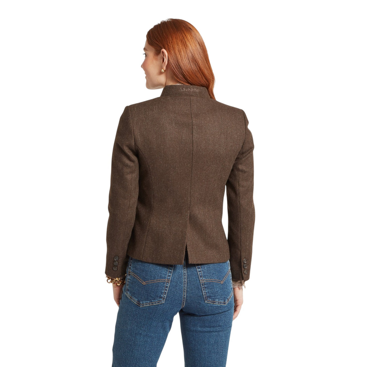Woman wearing a brown blazer and blue jeans on a white background