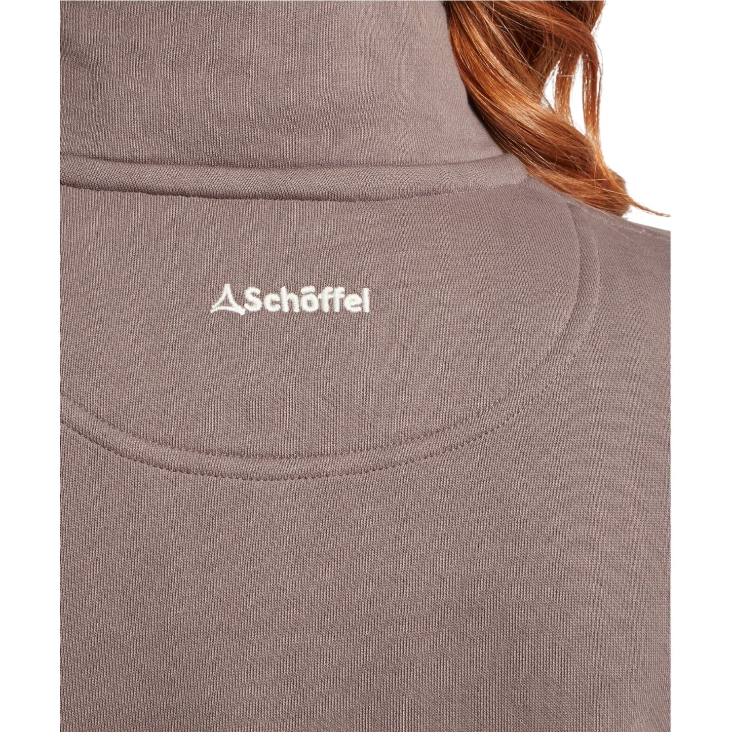 Close-up of a brown fabric with Schöffel logo, person wearing it.