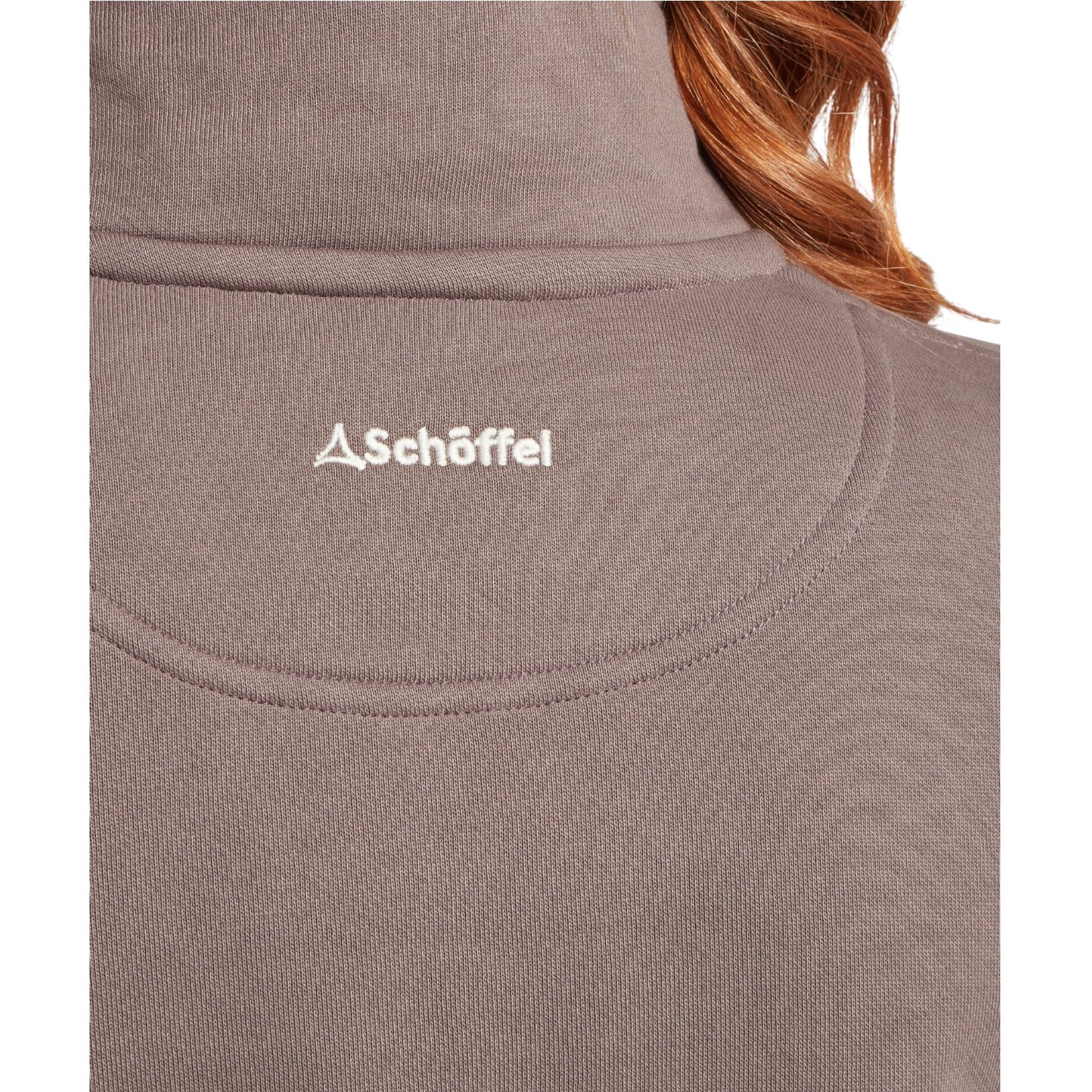 Close-up of a brown fabric with Schöffel logo, person wearing it.