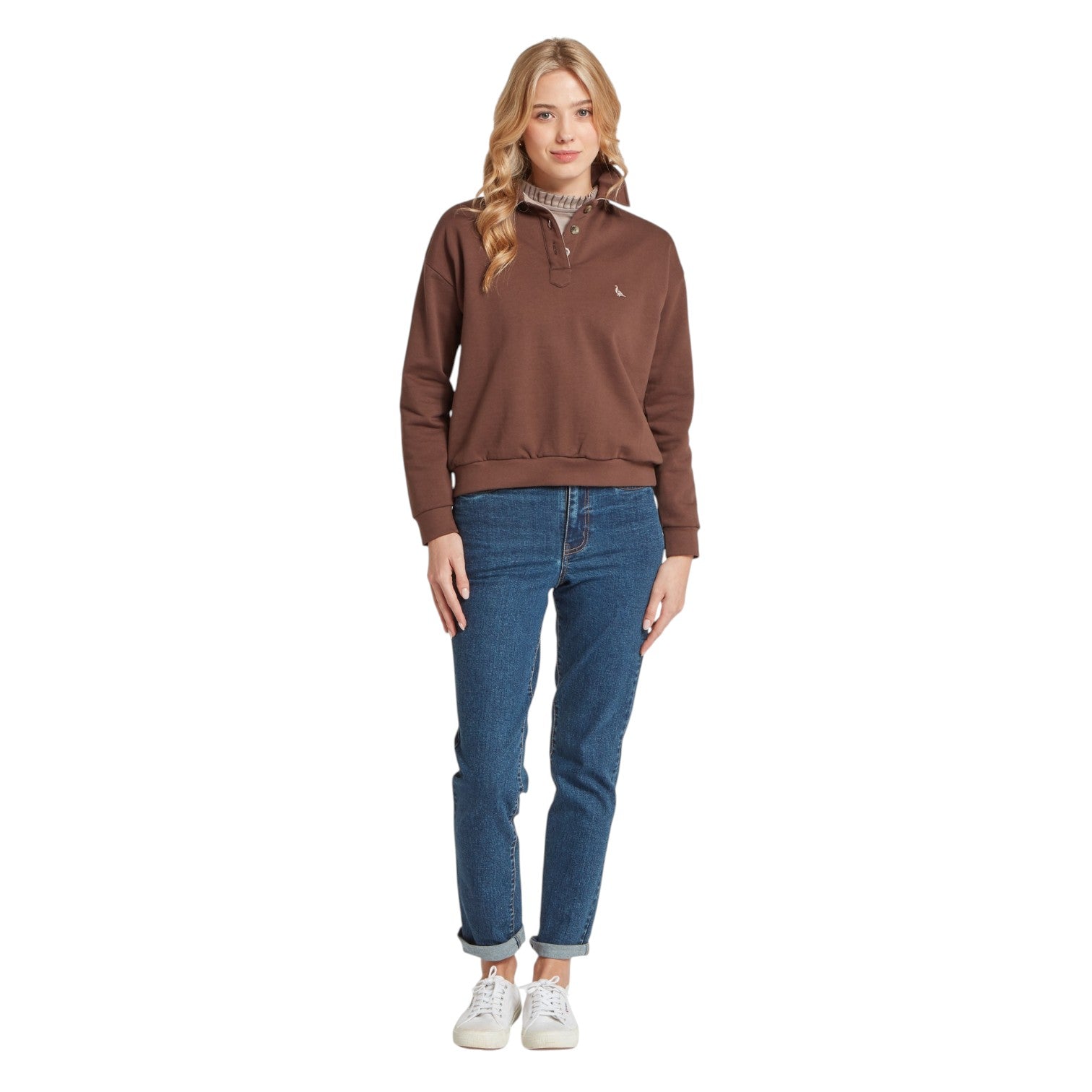 Woman wearing a brown pullover and blue jeans on a white background