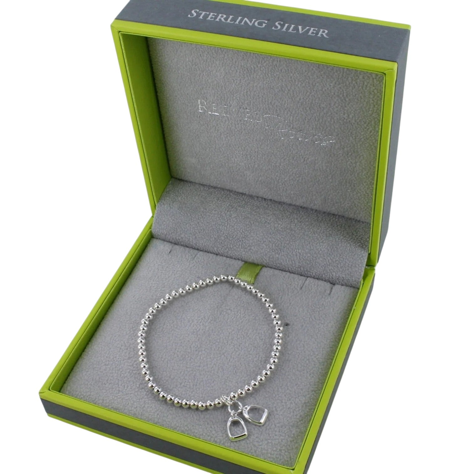 Silver bracelet with charms in a green and gray jewelry box labeled 'Sterling Silver'.