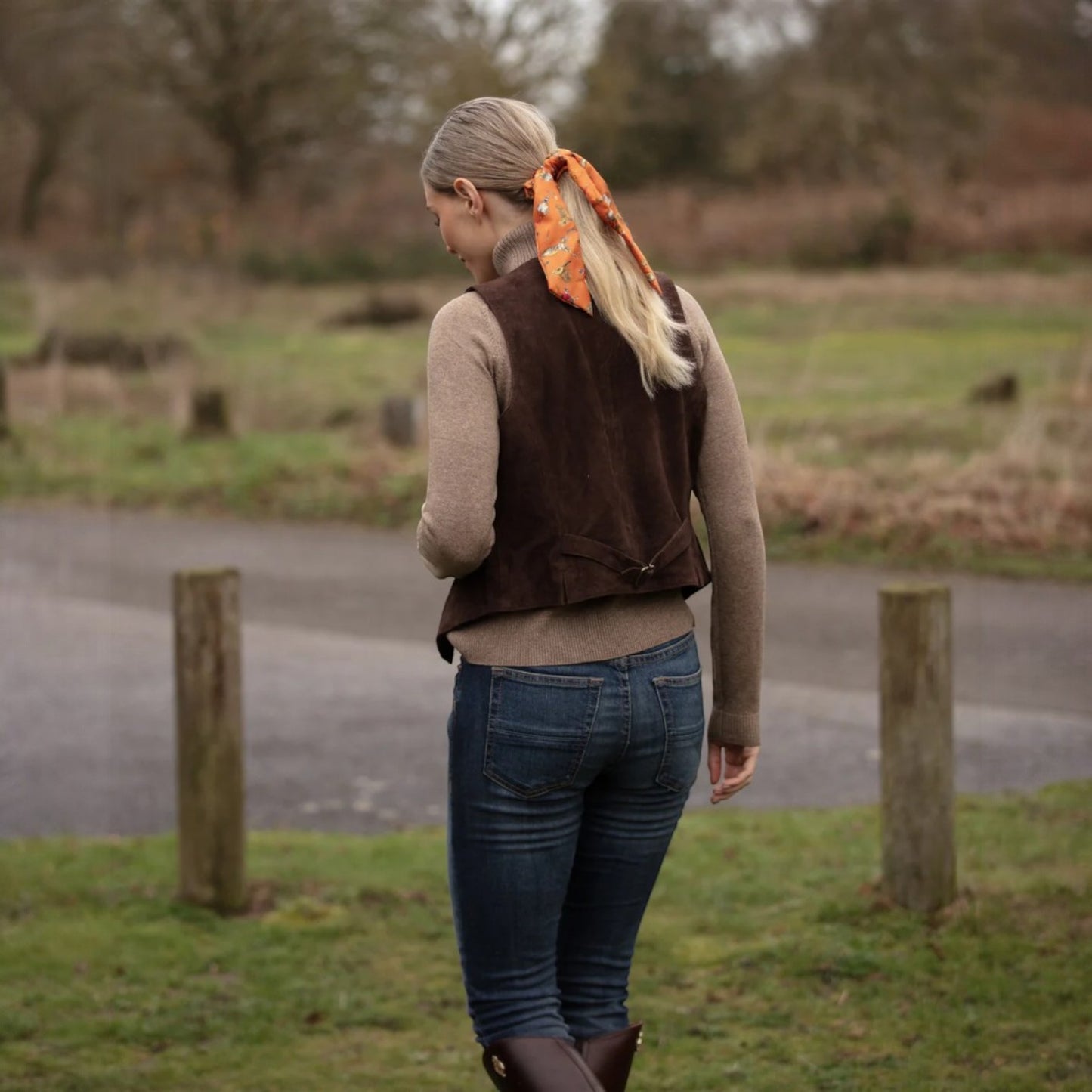 Woman walking outdoors in a natural setting with a vest and Clare Haggas Scrunchie