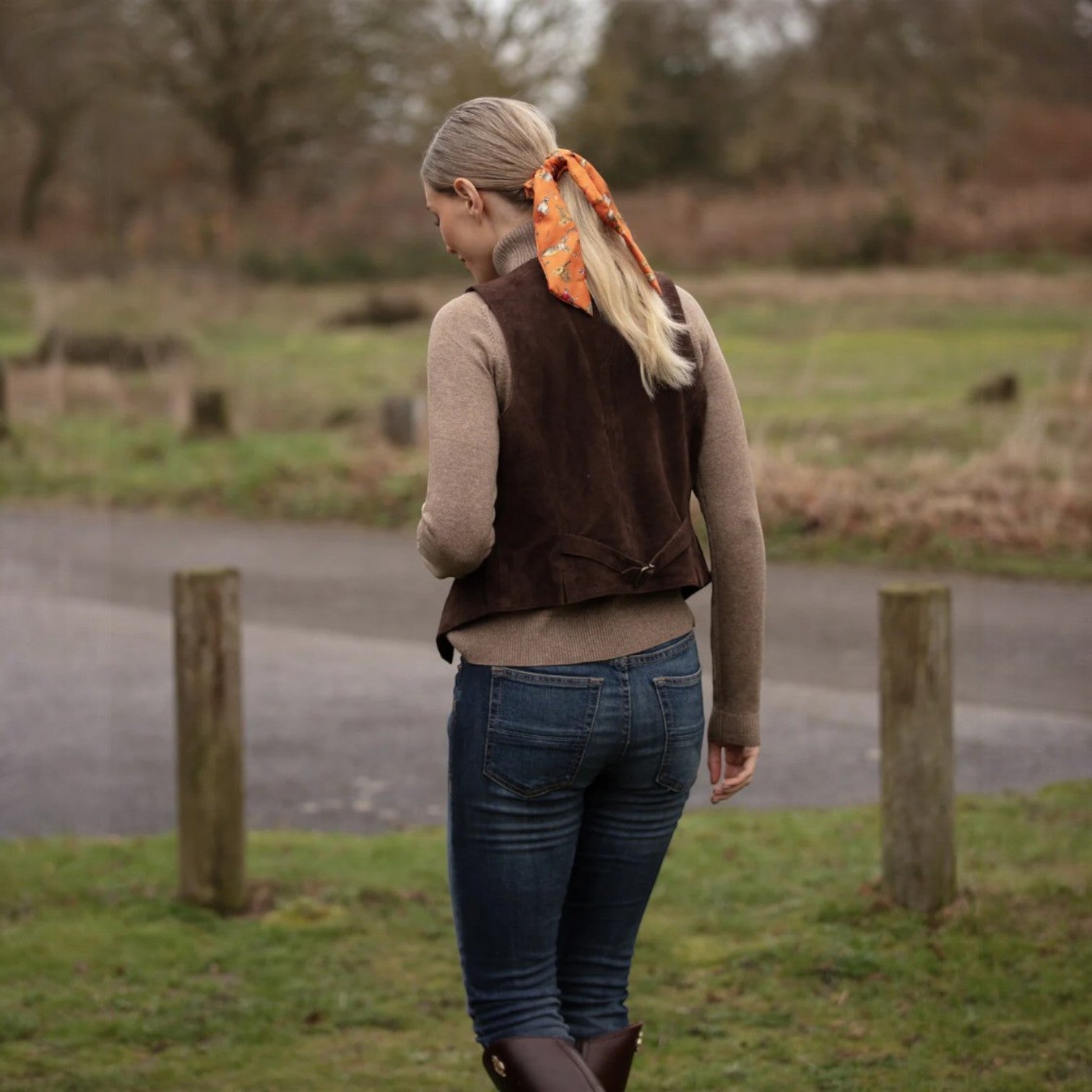 Woman walking outdoors in a natural setting with a vest and Clare Haggas Scrunchie
